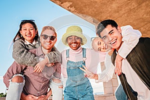 Group of five happy young friends having fun together adn smiling.