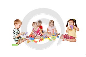 Group of five little children playing and building