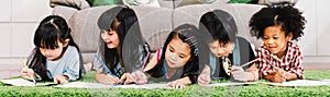 Group of five multi-ethnic young cute preschool kids, boy and girls happy study or drawing together at home or school