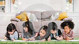 Group of five multi-ethnic young cute preschool kids, boy and girls happy studying or drawing together at home or school