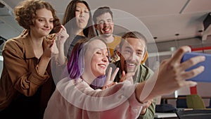 A group of five students are taking funny photos together, being in the auditorium in the university, slow motion