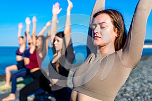 Group of five women practicing yoga assans in morning beach . only girls session