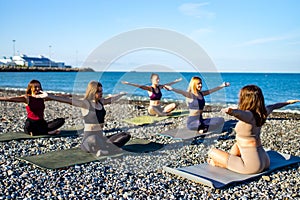 Group of five women practicing yoga assans in morning beach . only girls session