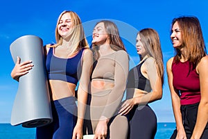 group of five women practicing yoga assans in morning beach . only girls session