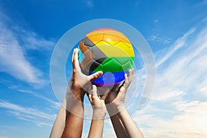 Grupo de fútbol americano aficionados posesión balón de fútbol vistoso progreso arcoíris bandera en azul nublado el cielo. libertad a. orgullo 