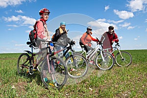 A group of four adults on bicycles.