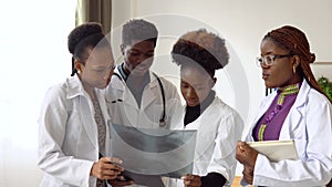 A group of four african american students discuss an x-ray
