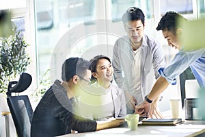 Group of four asian teammates working together discussing business in office