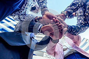 A group of four black afro american friends men businessmen in stylish business suit, expensive wristwatch handshake