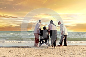 Group of four cheerful elderly old senior have trip outdoor, happy disabled senior elderly woman in wheelchair travel with friends