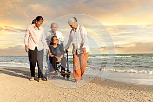 Group of four cheerful elderly old senior have a trip outdoor together, happy disabled senior elderly woman in wheelchair travel