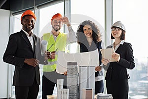 Group of four colleagues standing near building complex prototype project