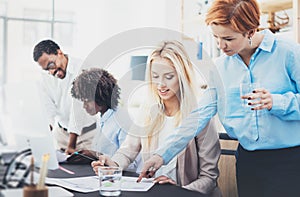 Group of four coworkers discussing business plans in an office. Young people making great ideas. Horizontal, blurred background.