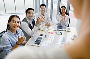 Group of four diversity businessmen, two men and three women sitting at meeting desk and pay high attention for the standing