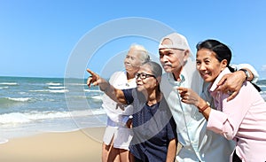 Group of four elderly old senior friends traveling outdoor together, pointing at something, have fun and enjoy spending time on