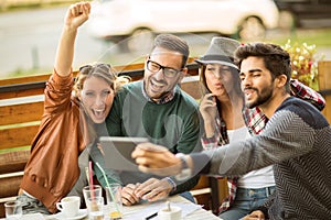 Group of four friends having a coffee together.