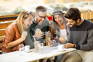 Group of four friends having a coffee together.