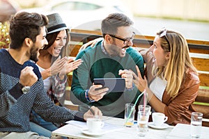 Group of four friends having a coffee together.