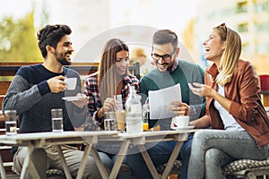 Group of four friends having fun a coffee together.