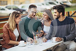 Group of four friends having fun a coffee together.