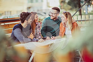 Group of four friends having fun a coffee together.