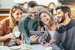 Group of four friends having fun a coffee together.