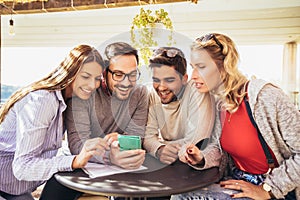 Group of four friends having fun a coffee together.