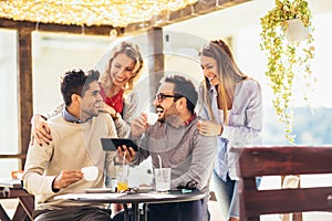 Group of four friends having fun a coffee together.