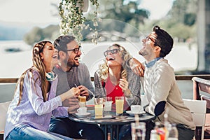 Group of four friends having fun a coffee together.