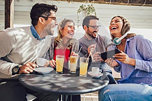 Group of four friends having fun a coffee together.