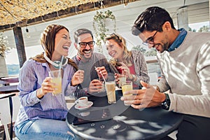 Group of four friends having fun a coffee together.