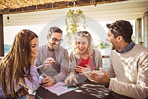 Group of four friends having fun a coffee together.