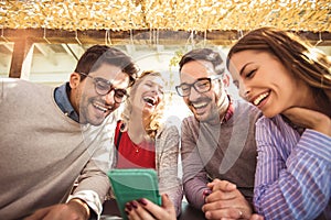 Group of four friends having fun a coffee together.