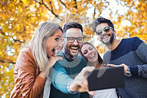 Group of four funny friends taking selfie