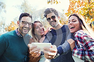 Group of four funny friends taking selfie