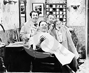 Group of four men at a barber shop singing