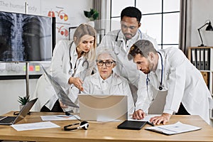 Group of four multiethnic medics having consilium in clinic