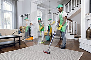 Group of four multiracial people cleaning client house