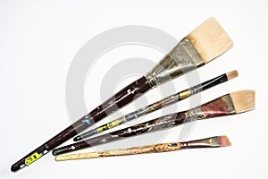 Group of four paint brushes spread out.