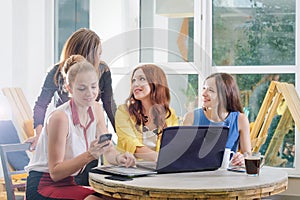 Group of four pretty businesswoman working togeather with new startup project using laptop computer in modern loft