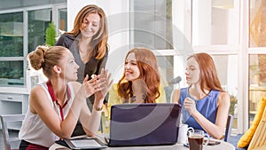 Group of four pretty businesswoman working togeather with new startup project using laptop computer in modern loft