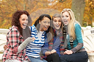 Group Of Four Teenage Girls Sitting On Bench