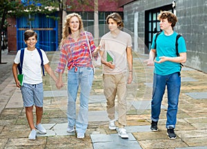 Group of four teens going home from school