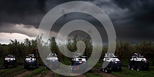 A group of four vehicles parked next to each other in a field. AI generative image