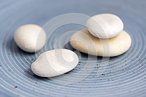 Group of four white pebbles on blue background, simplicity stone cairn with zenstones photo