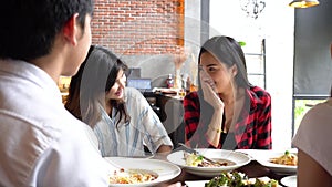 Group of Four young Asian people, eating and talking at cafe and restaurant. Friendship concept