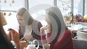 Group of four young people sitting at table in restaurant and having fun while dining.