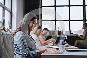 Group of freelancers and remote businesspeople working in shared work area. Concept of coworking, common workspaces for