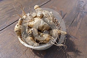 Group of fresh jerusalem artichokes on wooden table background, close up, top view