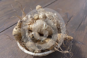 Group of fresh jerusalem artichokes on wooden table background, close up, top view